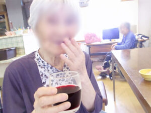入居者が室内で飲み物を持つ生活風景